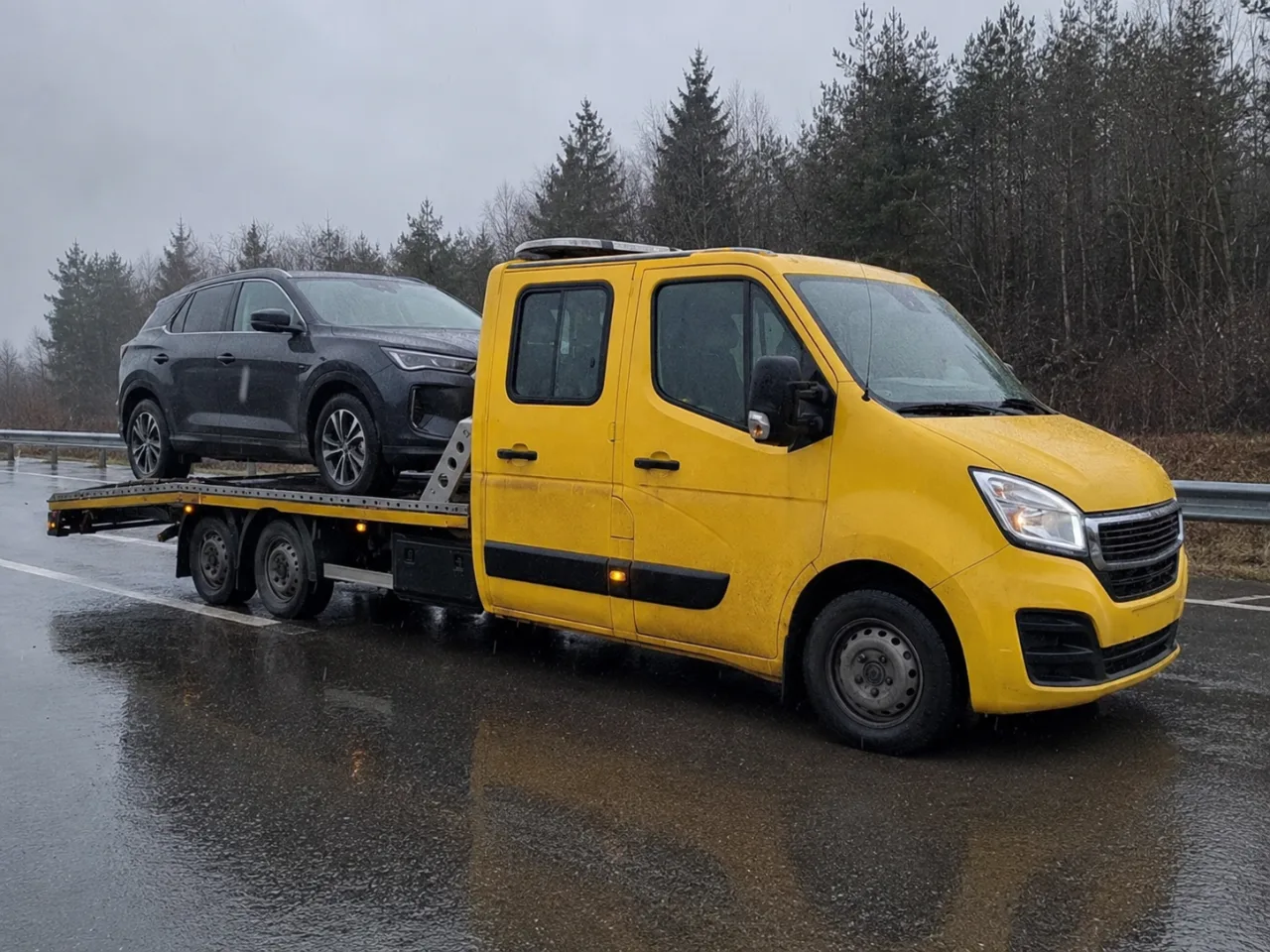 Holowanie srebrnego SUV-a na lawecie w deszczu – Rumia